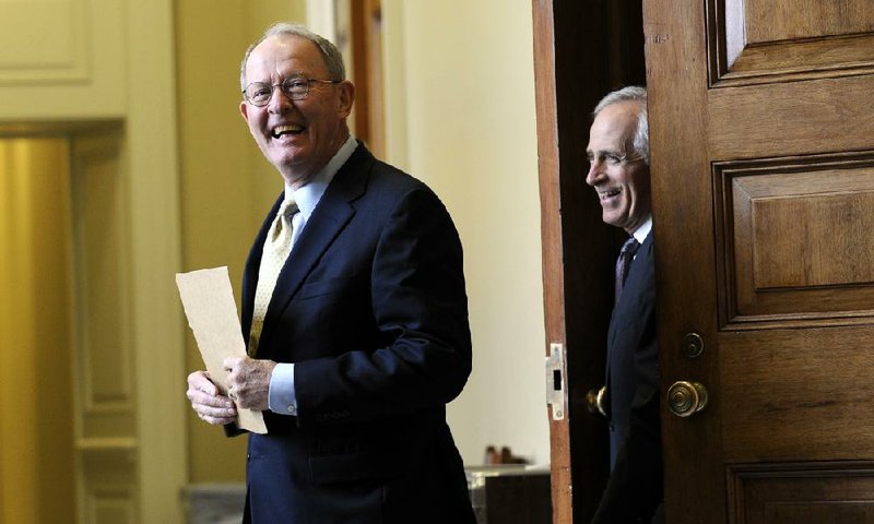 Sens. Lamar Alexander (left) and Bob Corker, both Republicans from Tennessee, walk out of a meeting of Senate Republicans earlier this month during budget negotiations. Alexander is one of the Republicans being targeted by a faction of the GOP to be ousted in the 2014 primaries. 