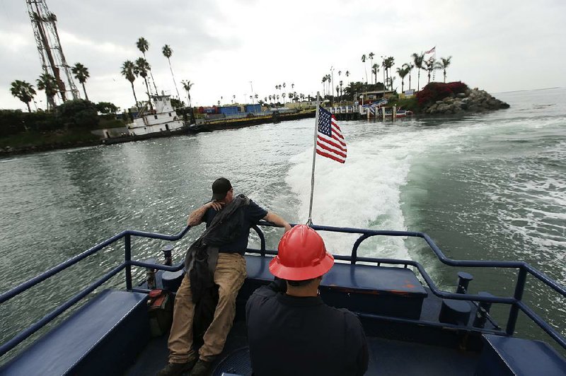 A oil workers sits during a ferry ride away from Freeman Island, one of the four artificial THUMS islands in San Pedro Bay off the coast of Long Beach used for oil drilling Thursday, Oct. 3, 2013 in Long Beech, Calif. Oil companies have fracked from man-made islands off Long Beach and platforms off the Orange County coast for years, and state regulators are only now realizing that the technique is more widespread than originally thought. (AP Photo/Chris Carlson)