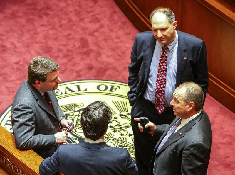 Sen. Bruce Maloch, D-Magnolia, (bottom right) talks with (clockwise from bottom) Sen. David Sanders, R-Little Rock, Sen. Jason Rapert, R-Bigelow, and Sen. Bruce Holland, R-Greenwood, on the Senate floor Friday, the second day of a special legislative session. Maloch didn’t bring up the bill he sponsored to take some property tax revenue from a handful of school districts. The House Education Committee had blocked an identical House bill earlier in the day. 