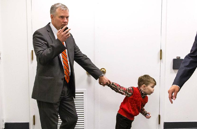 Rep. Tim Griffin (left) of Arkansas is tugged along by his son, John, as he and other Republican lawmakers arrive Oct. 8 on Capitol Hill for a strategy session. 