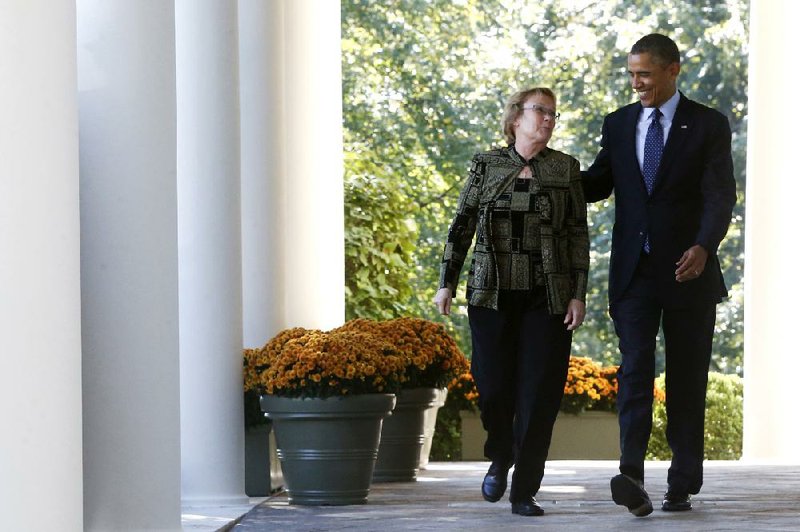 President Barack Obama walks from the Oval Office to the Rose Garden of the White House in Washington, Monday, Oct. 21, 2013, with Janice Baker, who runs a small business in Selbyville, Del., and was the first woman to enroll in the Delaware health care exchange, for an event on the initial rollout of the health care overhaul. Obama acknowledged that the widespread problems with his health care law's rollout are unacceptable, as the administration scrambles to fix the cascade of computer issues. (AP Photo/Charles Dharapak)