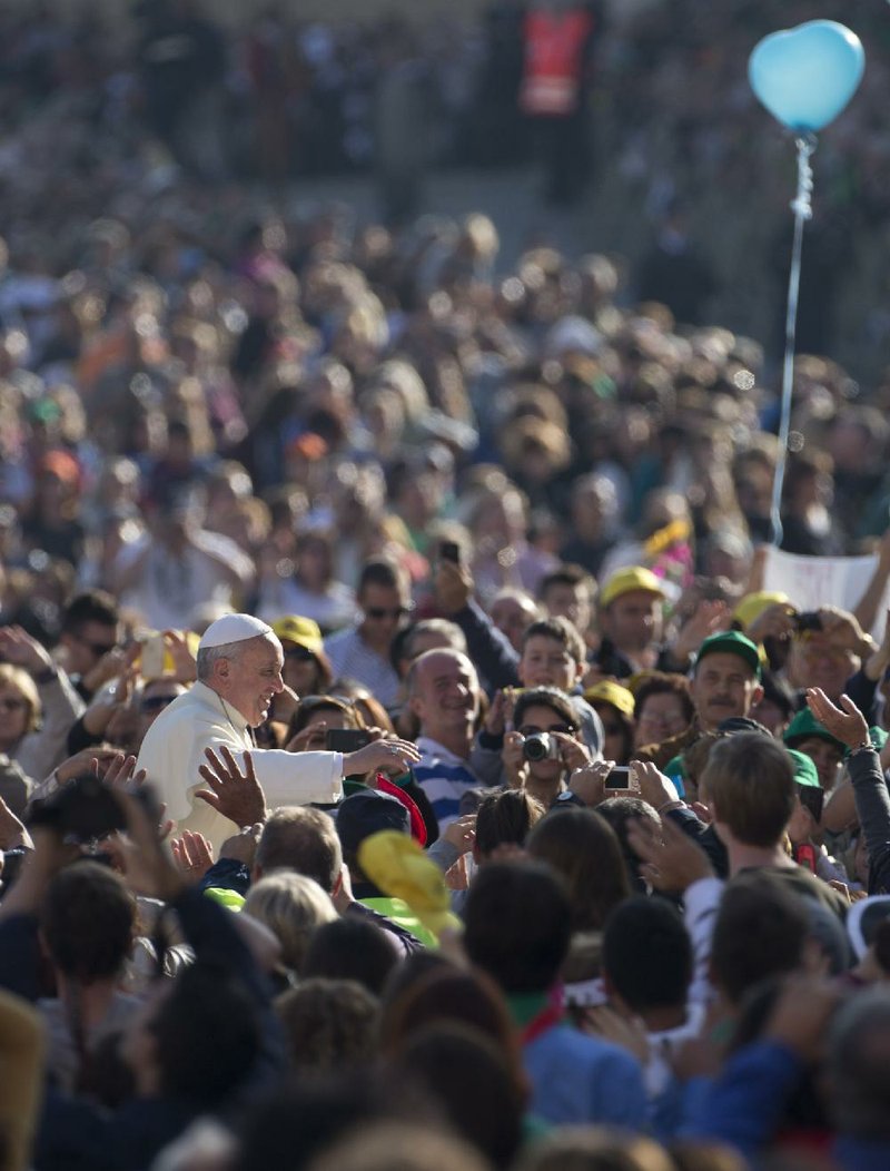 Pope Francis greets the crowd Wednesday as he driven to his weekly general audience in St. Peter’s Square at the Vatican. 