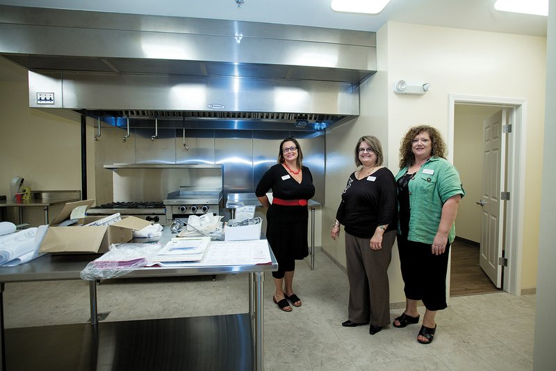 Former Bethlehem House resident and board member, Beth Eakin, left, and Chairwoman of the board, Aimee Prince and board member Marsha Mayfield in the new kitchen area.