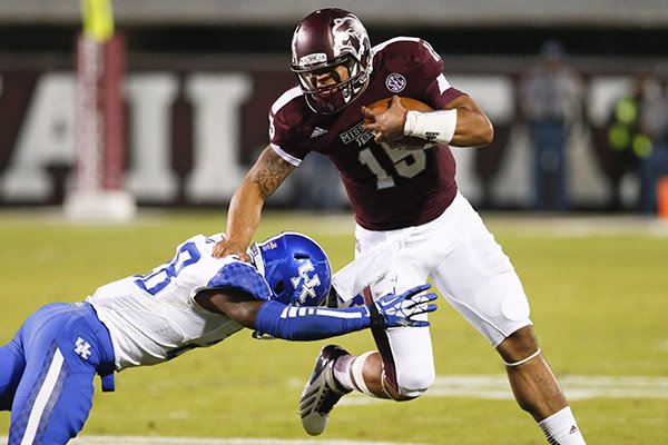 Mississippi State quarterback Dak Prescott (15) fights off a tackle attempt by Kentucky safety Eric Dixon (28) as he runs for long yards in the first half of their NCAA college football game at Davis Wade Stadium in Starkville, Miss., Thursday, Oct. 24, 2013. (AP Photo/Rogelio V. Solis)