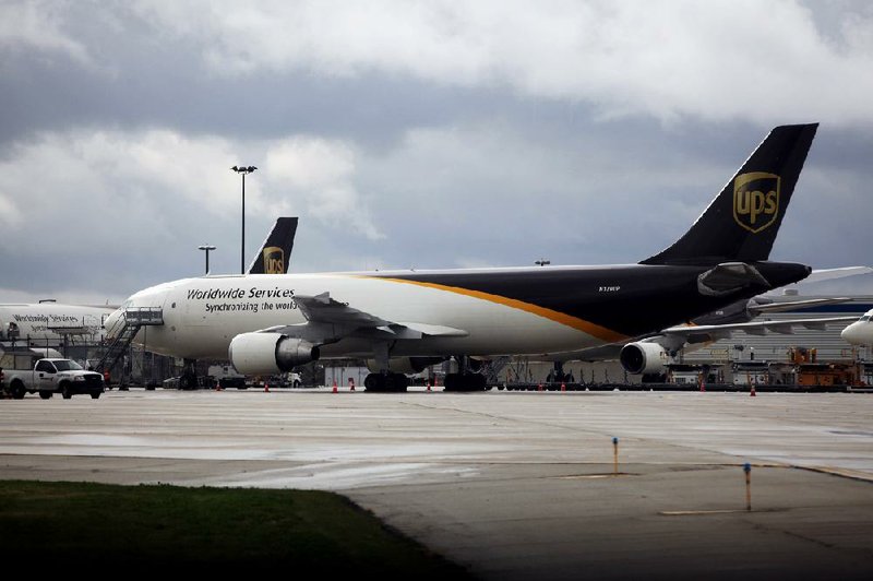 A United Parcel Service Inc. jet is parked at O’Hare International Airport in Chicago last week at an event to mark the opening of a new runway. UPS reported a quarterly profit of $1.1 billion on Friday. 