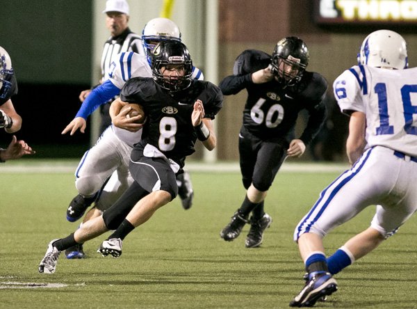 Hunter Laney (8) of the Freshman Tigers running the quarterback keeper as Gary Fredrick (16) of the Mountaineers squares up for the tackle  at Tiger Stadium in Bentonville on October 24. 2013.