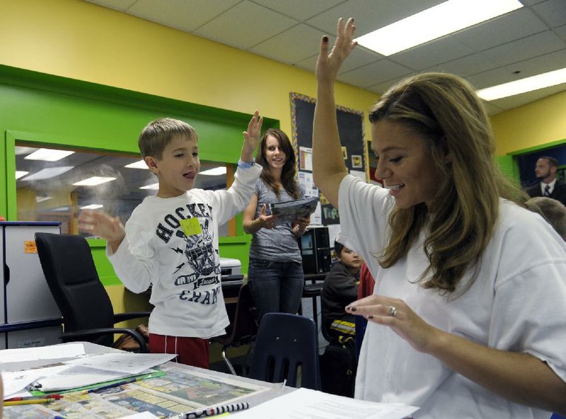 Josh Gillespie, 8, high-fives parent helper Shannon Morgan after they solved a math problem at the Andrews Air Force Base, Md., home-schooling cooperative with math teacher Jennifer Whittaker. 