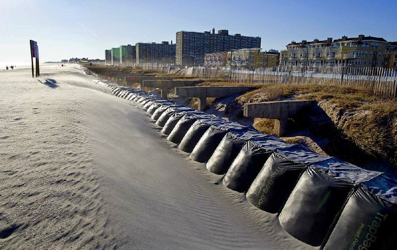 This Monday, Oct. 21, 2013 photo shows reinforced dunes and the buried remains of the former boardwalk along a beach in the Rockaway neighborhood in the borough of Queens, New York. A year after Superstorm Sandy, New York City’s submerged subways and tunnels sprang back to life with surprising speed. Beach boardwalks were rebuilt and mountains of debris were removed. And while some beach towns quickly rebuilt their seaside promenades and beaches, for every success story, there are tales of continuing frustration. (AP Photo/Craig Ruttle)