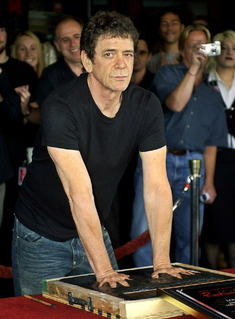 FILE - In a June 24, 2003 file photo, music icon Lou Reed has his hands imprinted as supporters cheer in the background as he is inducted into Hollywood's Rockwalk, in the Hollywood section of Los Angeles. Punk-poet, rock legend Lou Reed is dead of a liver-related ailment, his literary agen said Sunday, Oct. 27, 2013. He was 71.(AP Photo/Ric Francis, File)