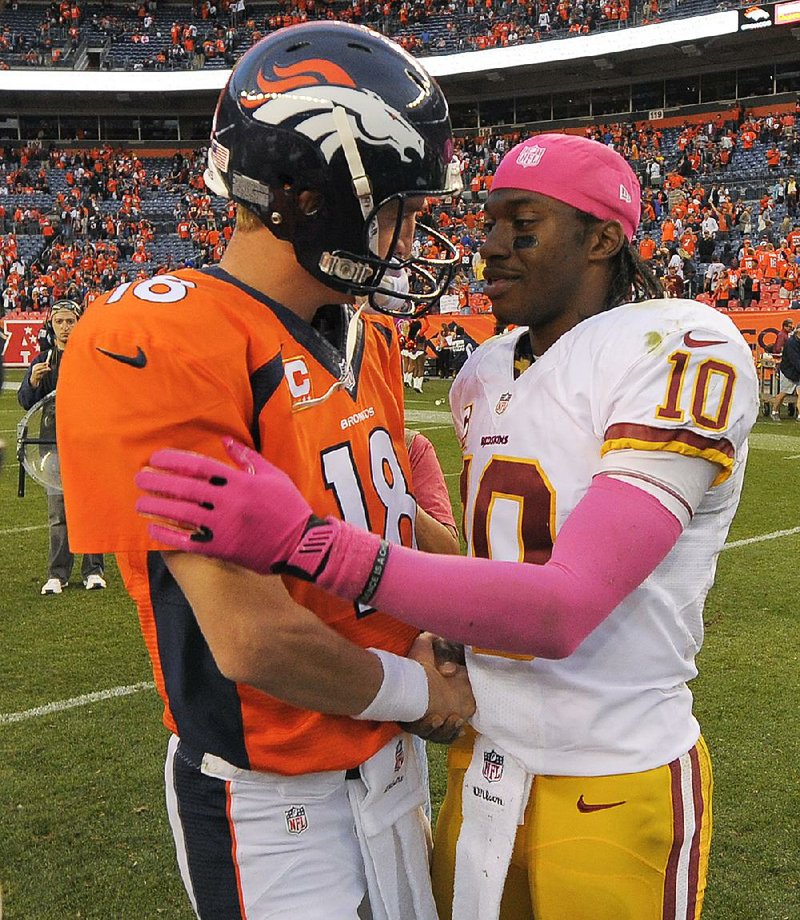 Denver Broncos quarterback Peyton Manning (18) greets Washington Redskins quarterback Robert Griffin III (10) after the Broncos beat the Redskins 45-21 in an NFL football game, Sunday, Oct. 27, 2013, in Denver. (AP Photo/Jack Dempsey)