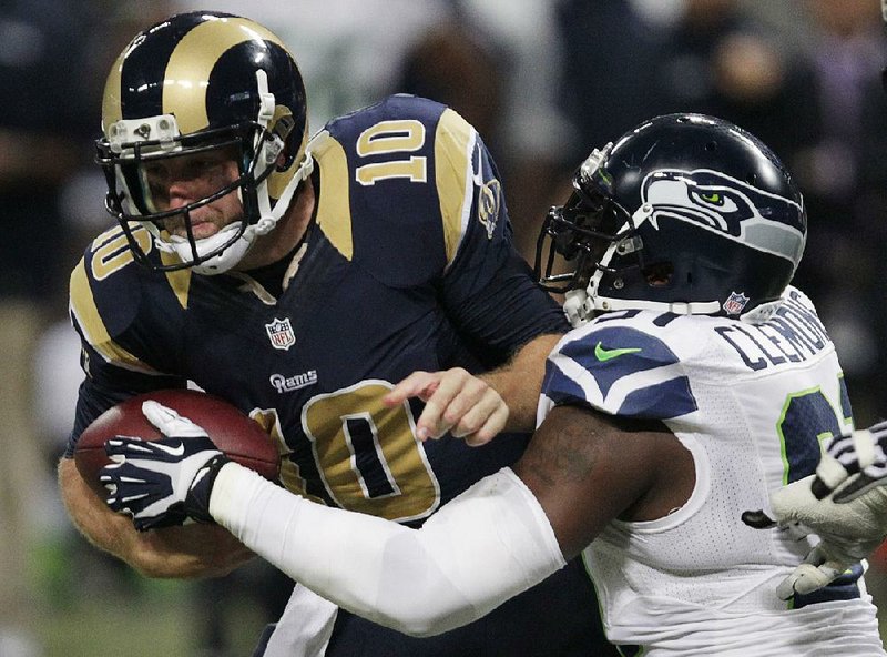 St. Louis Rams quarterback Kellen Clemens (10) runs against Seattle Seahawks defensive end Chris Clemons (91) during the first half of an NFL football game, Monday, Oct. 28, 2013, in St. Louis. (AP Photo/Tom Gannam)