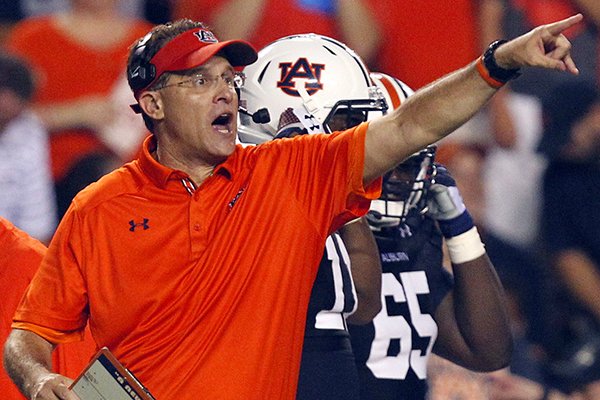 In this Aug. 31, 2013 file photo, Auburn head coach Gus Malzahn signals to his players during the second half of an NCAA college football game against Washington State in Auburn, Ala. (AP Photo/Butch Dill)