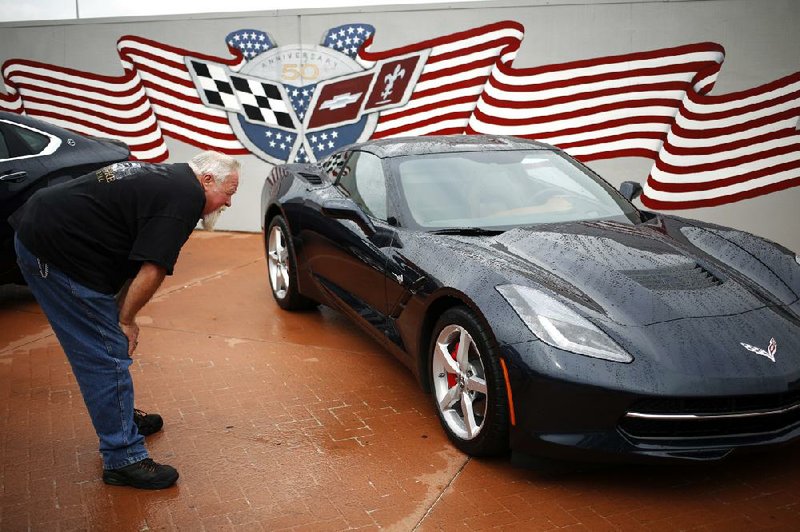 Robert Beattie of New Orleans looks at a 2014 Chevrolet Corvette Stingray outside the General Motors Co. Bowling Green Assembly Plant in Bowling Green, Ky., earlier this month. GM, which reported its third-quarter earnings on Wednesday, has now been profitable for 15 straight quarters. 