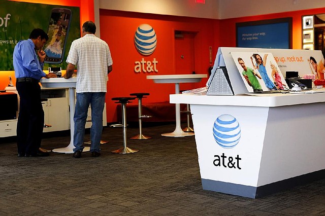 A salesman helps a customer at an AT&T store in Manhattan Beach, Calif., earlier this year. Sources say AT&T is preparing for a potential takeover of Europe’s largest mobile carrier, Vodafone Group PLC. 