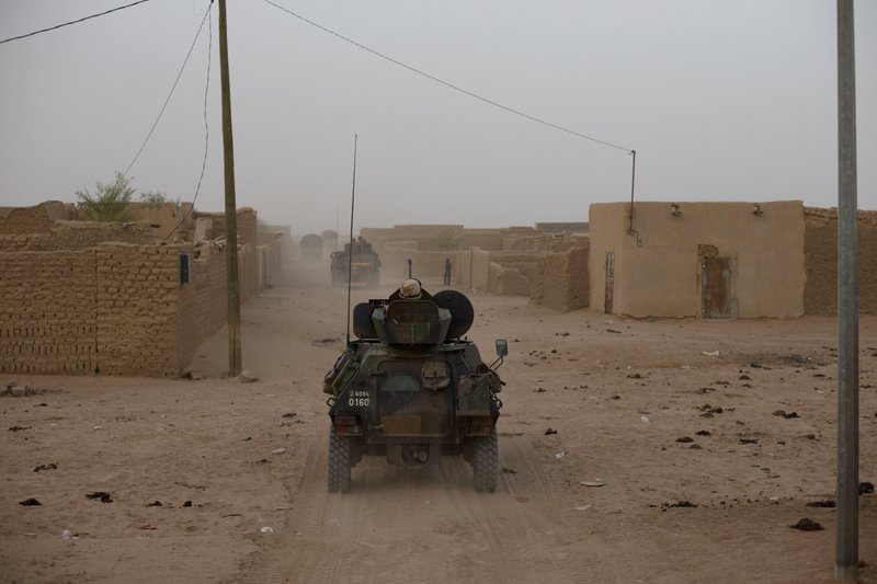 In this July 28, 2013 file photo, a French military convoy drives through a neighborhood of Kidal in northern Mali. Mali's military chief in Kidal said Saturday, Nov. 2, 2013, that two journalists working for French radio station RFI have been kidnapped. RFI confirmed the kidnappings on its website, saying that journalists Ghislaine Dupont and Claude Verlon were taken at 1 p.m. Saturday by armed men in Kidal and have not been heard from since. (AP Photo/Rebecca Blackwell, File)