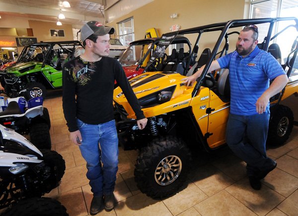 Jeremy Roberts, left, talks with salesman John Bell in front of a Kawasaki Teryx side-by-side utility vehicle while shopping for an all-terrain vehicle to use on his property in Clifty at Rainbow Cycle & Marine in Rogers on Saturday November 2, 2013. Rainbow Cycle & Marine has seen an increased interest in side-by-side vehicles like the Teryx.