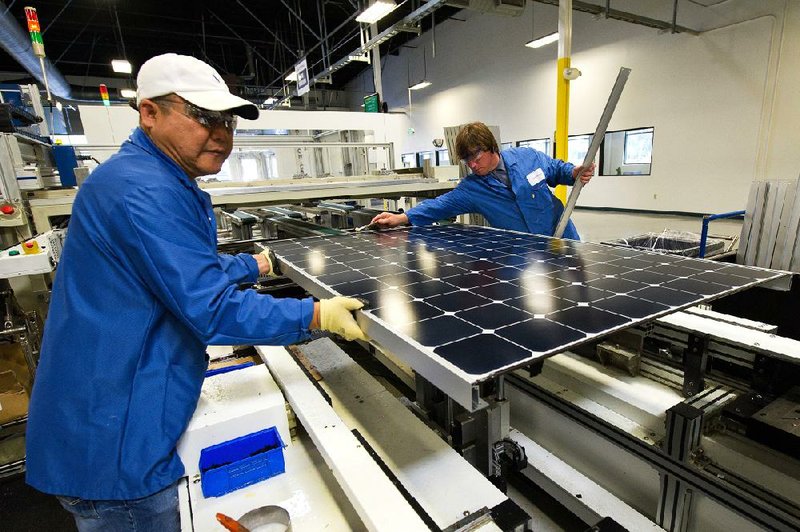 Employees of SunPower Corp. assemble the edges of solar panels at the SunPower Corp. module manufacturing plant at Flextronics in Milpitas, California, U.S., on Wednesday, Aug. 24, 2011. SunPower Corp., a Silicon Valley manufacturer of high-efficiency solar cells, solar panels and solar systems, announced today that Akuo Solar, a subsidiary of Paris-based Akuo Energy, has ordered 75,000 high efficiency SunPower solar panels for Akuo's planned 24-megawatt solar development. Photographer: David Paul Morris/Bloomberg