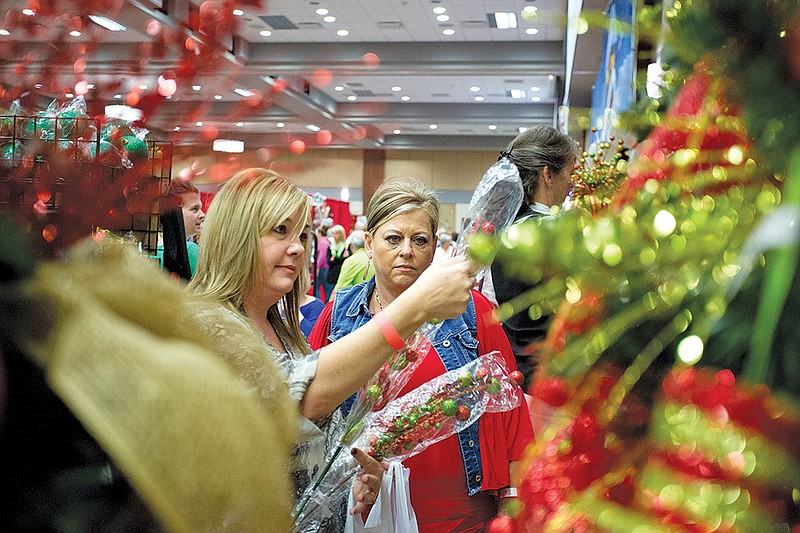 Sandy Purifoy, left, and Sue Uchtman, both of Gurdon, look at Christmas decorations during the Glitz and Garland Holiday Shopping Event held Friday in Benton.