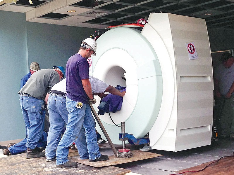 Using special rolling jacks, a new 5.1-ton MRI unit is hand-pushed into the imaging suite at Mercy Hospital Hot Springs. The unit provides more room for a patient during a scan.