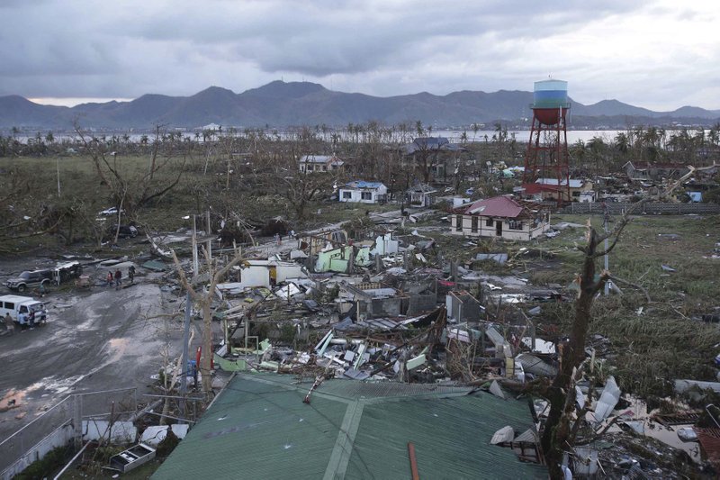 Houses are damaged after powerful Typhoon Haiyan slammed into Tacloban, central Philippines on Saturday, Nov. 9, 2013. Rescuers in the central Philippines counted at least 100 people dead and many more injured Saturday, a day after one of the most powerful typhoons on record ripped through the region, wiping away buildings and leveling seaside homes with massive storm surges. (AP Photo/Aaron Favila)