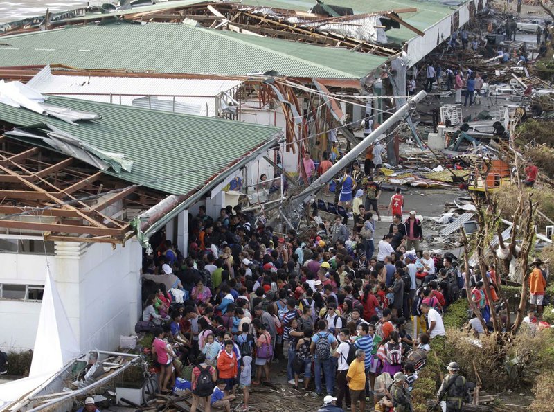 Residents queue up to receive treatment and relief supplies at Tacloban airport Monday Nov. 11, 2013, after Friday's typhoon Haiyan that lashed this city and several provinces in central Philippines. 