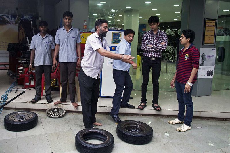 An Apollo Tyres Ltd. employee talks to customers at the company’s Apollo Super Zone store in Mumbai, India, in June. 