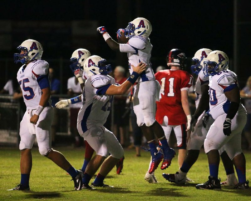 Arkadelphia running back Kris Oliver (center) celebrates with teammates after running for a firsthalf touchdown in a 56-6 victory over Arkansas Baptist on Oct. 4. Oliver is among eight returning offensive starters for the Badgers, who have scored at least 42 points in nine games. 