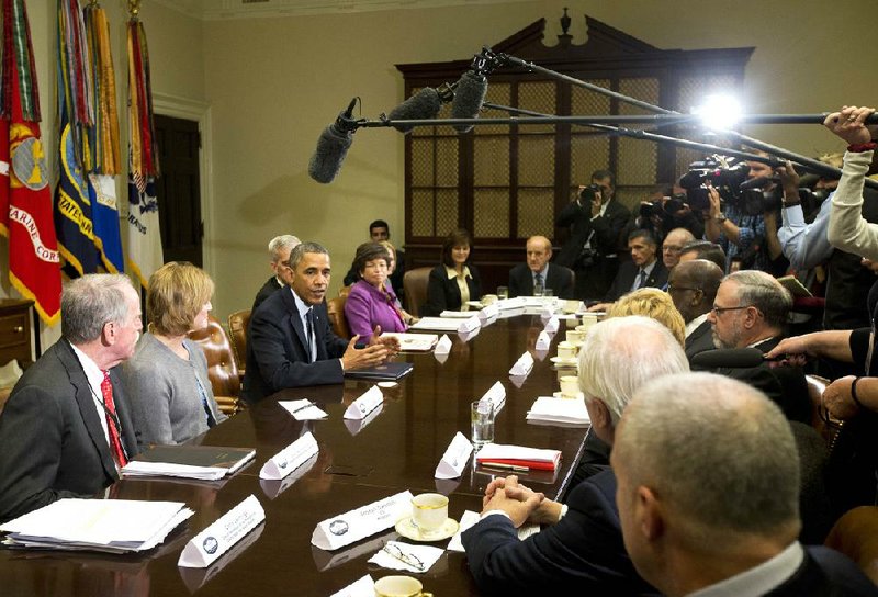 President Barack Obama talks to several aides Friday at the White House before the start of a meeting with representatives of health-insurance companies about the problems with the rollout of the healthcare law. 