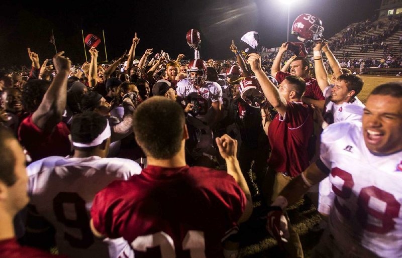Henderson State players, coaches and fans celebrate after the Reddies defeated Ouachita Baptist in three overtimes in the 87th Battle of the Ravine on Saturday in Arkadelphia. 