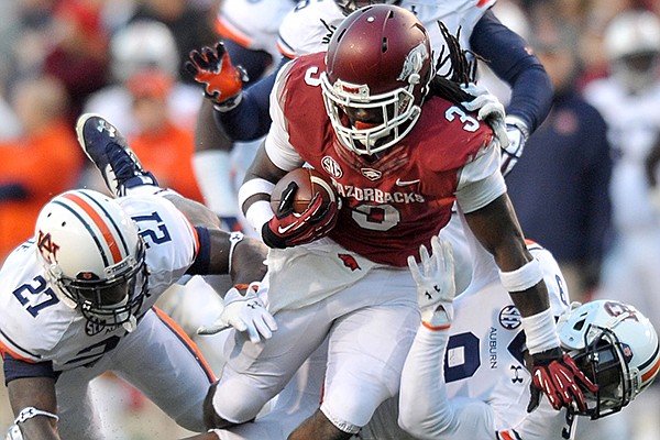 University of Arkansas running back Alex Collins is taken down by Auburn defenders Robenson Therezie and Jermain Whitehead during the second quarter of Saturday night's game at Razorback Stadium in Fayetteville.