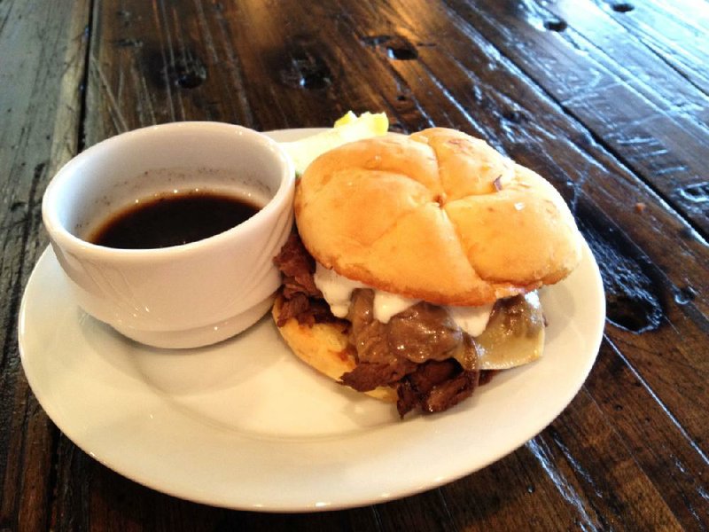 The French Dip sandwich comes au jus with a side of apple slices at Mugs Cafe in North Little Rock’s downtown Argenta district. 
