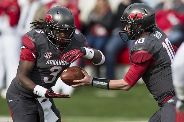 Alex Collins receives a hand off from QB Brandon Allen during their game against Mississippi State on Nov. 23, 2013 at War Memorial Stadium in Little Rock. 