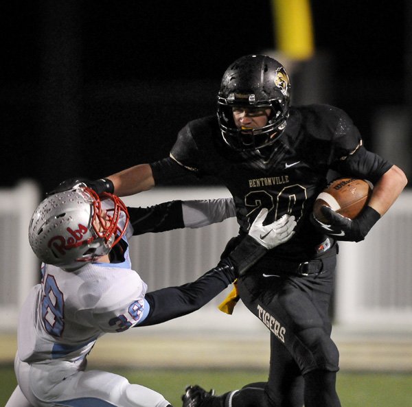 Bentonville wide receiver Cody Scroggins breaks the tackle of Fort Smith Southside defensive back Jace McCrea in the second quarter of the first round 7A playoffs game on Friday November 22, 2013 in Bentonville's Tiger Stadium.