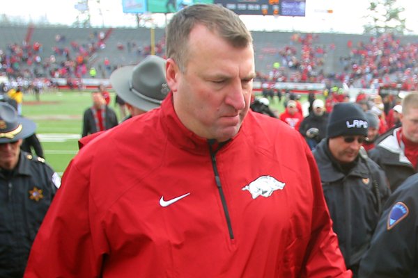 Arkansas coach Bret Bielema and his team leave the field after a 24-17 overtime loss to Mississippi State Saturday at War Memorial Stadium in Little Rock.