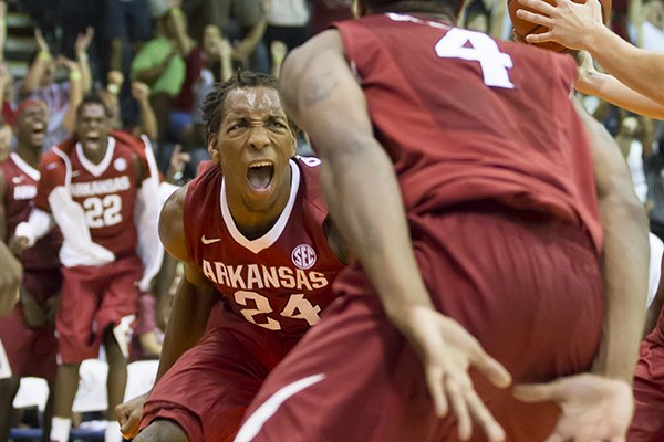 Arkansas guard Michael Qualls (24) reacts along with his teammate forward Coty Clarke (4) after dunking the ball against Minnesota in the second half of an NCAA college basketball game at the Maui Invitational on Tuesday, Nov. 26, 2013, in Lahaina, Hawaii. Arkansas won 87-73. (AP Photo/Eugene Tanner)