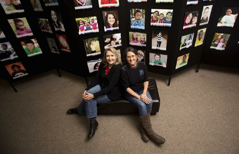 Christie Erwin (right) and Caryl Watson, co-directors of Project Zero, enlisted 30 volunteer photographers to create this new Heart Gallery. Folding panels display 125 portraits of children available for adoption. 