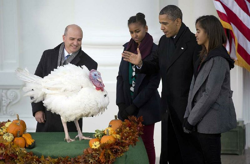 John Burkel of the National Turkey Federation in Badger, Minn., on Wednesday presents Popcorn to President Barack Obama and his daughters Malia (right) and Sasha at a White House pardoning ceremony. 