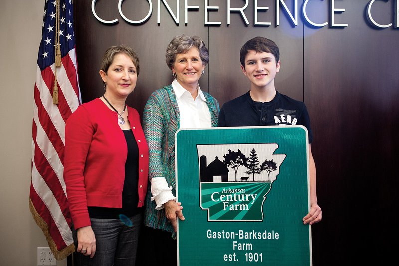 Carla Sue Barksdale of Melbourne, center, accepts the Arkansas Century Farm sign with her daughter Carla Edwards and grandson Tanner Edwards, 14, both of Lonoke.