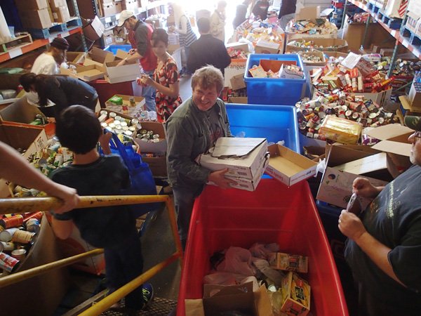 Curtis Dillahunty, center, a Samaritan Community Center employee, unloads a container of food at the center on Wednesday Nov. 27 2013 that was donated by two Rogers restaurants. Dillahunty picked up the items on Wednesday morning at Red Lobster and Olive Garden.