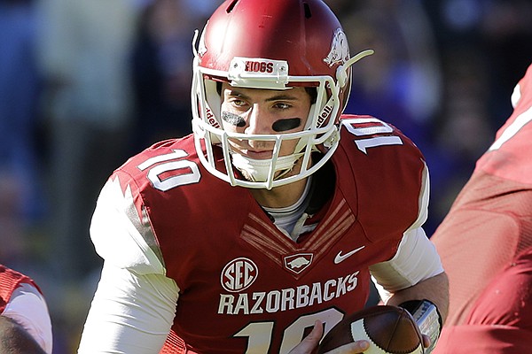 Arkansas quarterback Brandon Allen (10) drops back in the first half of an NCAA college football game against LSU in Baton Rouge, La., Friday, Nov. 29, 2013. (AP Photo/Bill Haber)