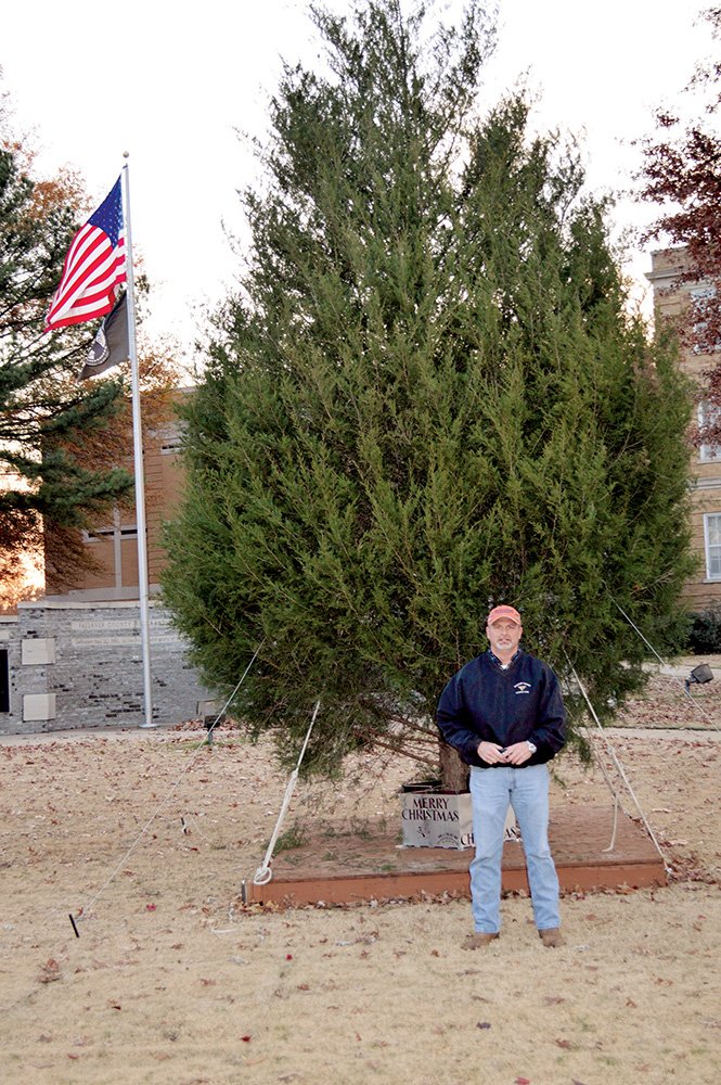 Faulkner County Judge Allen Dodson stands in front of the 22-foot Christmas tree on the courthouse lawn, 801 Locust St., that will be lit at 6:30 p.m. Tuesday. The tree was cut from his family farm. The courthouse will also be decorated with lights for the first time in at least 20 years, Dodson said.