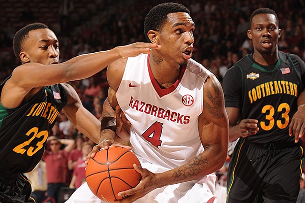 Arkansas forward Coty Clarke (4) drives to the lane as Southeastern Louisiana guard Joshua Filmore (23) defends during the first half of play Tuesday, Dec. 3, 2013, in Bud Walton Arena in Fayetteville.