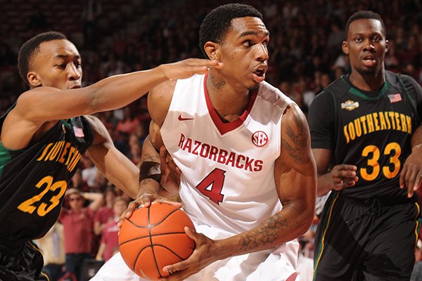 Arkansas forward Coty Clarke (4) drives to the lane as Southeastern Louisiana guard Joshua Filmore (23) defends during the first half of play Tuesday, Dec. 3, 2013, in Bud Walton Arena in Fayetteville.