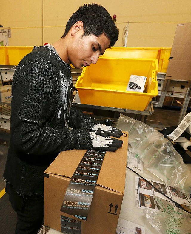 Employee Omar Murillo packs a box at an Amazon.com warehouse in Phoenix on Monday, the busiest online Christmas shopping day of the year. 