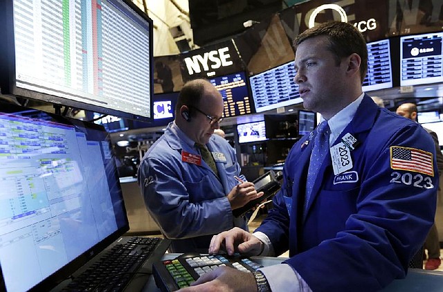 Specialist Frank Masiello (right) works Tuesday on the floor of the New York Stock Exchange. 