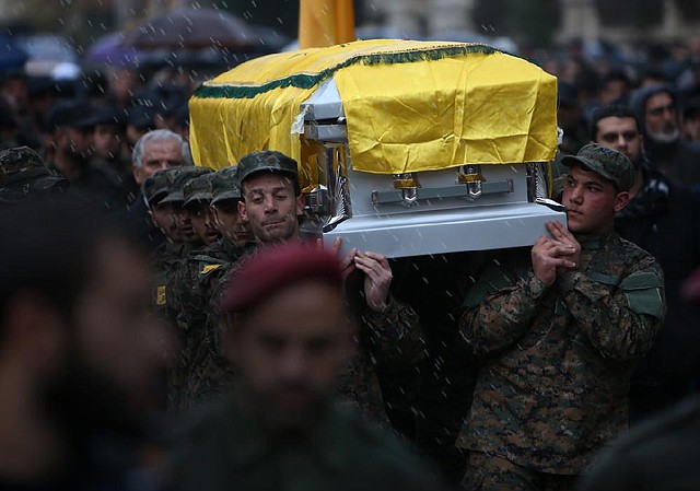 Hezbollah fighters carry the coffin of Hassane Laqees, a senior commander for the Lebanese militant group Hezbollah, who was gunned down outside his home Wednesday, during his funeral procession at his hometown of Baalbek city, east Lebanon. 