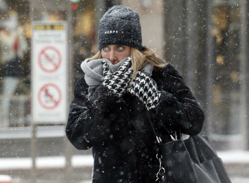In a preview of the storm system headed to Arkansas, a woman in Denver faces a wintry blast Wednesday.