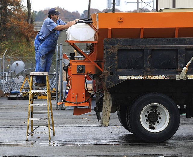 Arkansas Highway and Transportation Department worker Joe Andrews checks the tanks on a truck Wednesday in Little Rock in preparation for wintry weather. The tanks will be filled with calcium chloride to treat icy roads. 