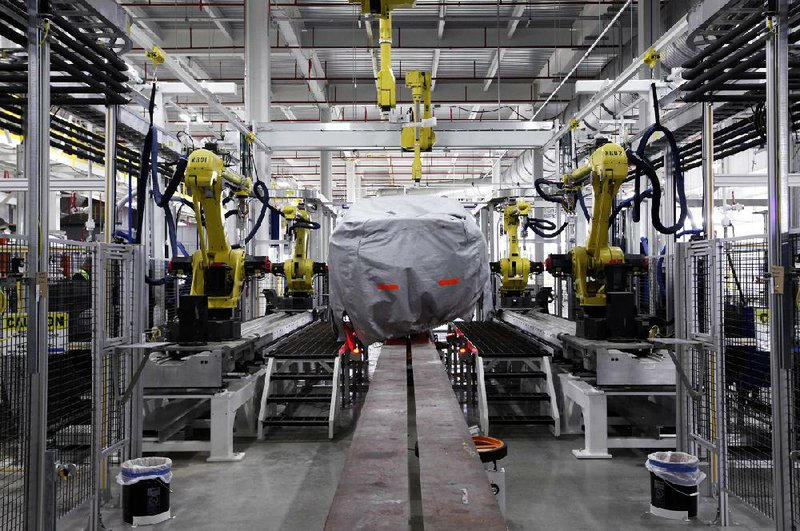 A covered vehicle sits in the new paint shop at Chrysler’s Sterling Heights Assembly Plant in Sterling Heights, Mich., in this fi le photo. The nation’s gross domestic product climbed at a 3.6 percent annualized rate in the third quarter, up from an initial estimate. 