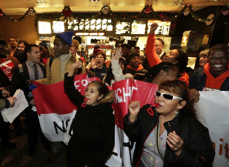 Demonstrators rally for higher wages Thursday inside a McDonald’s restaurant in New York. Fastfood workers and labor organizers want the federal government to raise the federal minimum wage of $7.25. 